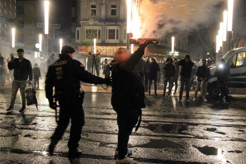 Ein Polizist fordert diesen Mann auf, mit der Feuerwerks-Batterie keine Menschen zu gefährden. Feuerwerk sollte auf keinen Fall in der Hand gezündet werden. (Archiv) Ein Polizist fordert diesen Mann auf, mit der Feuerwerks-Batterie keine Menschen zu gefährden. Feuerwerk sollte auf keinen Fall in der Hand gezündet werden. (Archiv)