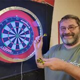 Hobby-Darter Frank Royek vor einer Dartscheibe.
