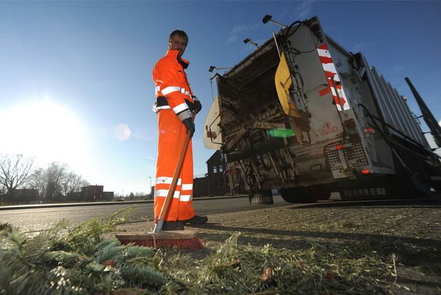 Ein Mitarbeiter des EUV sammelt alte Weihnachtsbäum in Castrop-Rauxel ein.