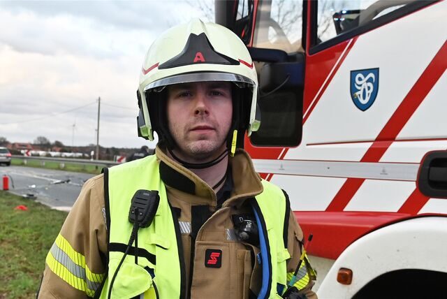 Dominik Dammann steht vor einem Feuerwehrfahrzeug