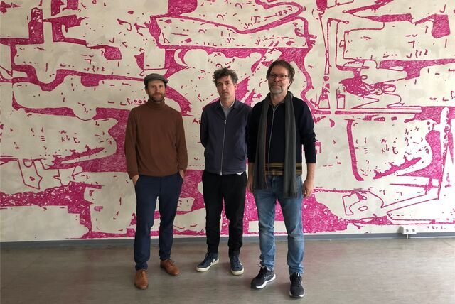 Haben die Ausstellung ins Leben gerufen: die Initiatoren Sebastian Freytag (li.) und Georg Elben (re.) stehen mit Künstler Christian Freudenberger vor seinem Wandbild.