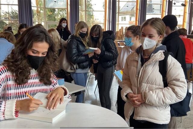 Autogrammstunde nach der Lesung: Mona Ameziane signiert ihr Buch für Schülerinnen und Schüler des ASGSG.