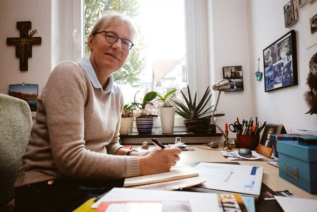 Schwester Judith – hier bei der Schreibtisch-Arbeit in ihrem Zimmer – gehört zur Kommunität des Gasthauses.