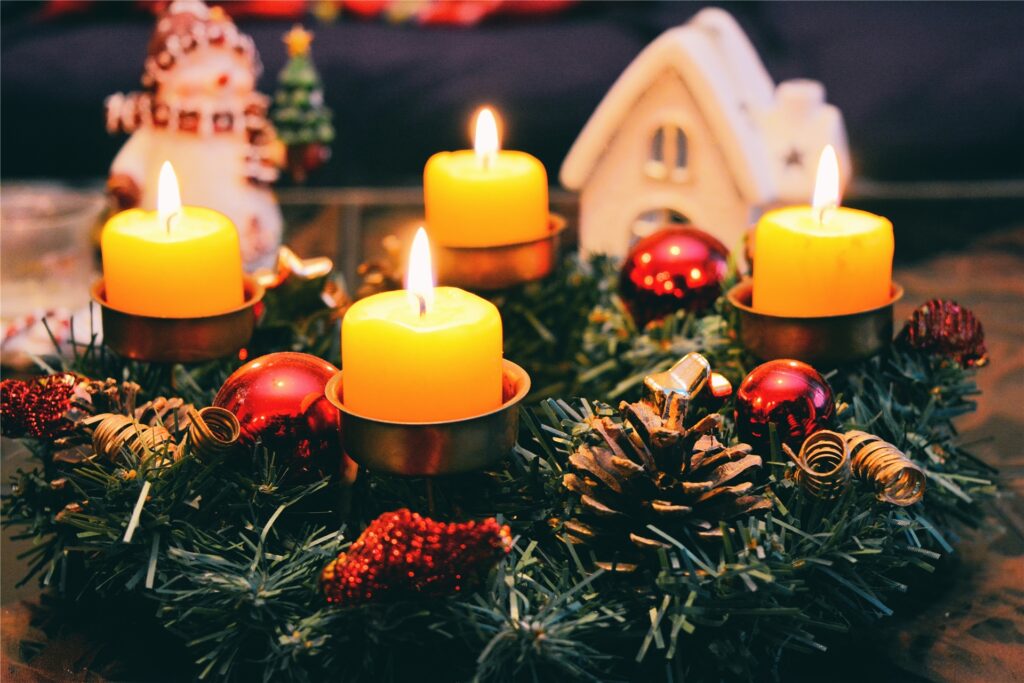 vier brennende kerzen auf einem adventskranz