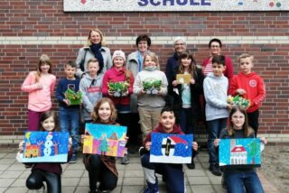 Kinder halten ihre selbst gemalten Kalender-Motive in den Händen