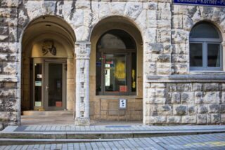 Einschusslöcher sind auf einer verglasten Tür zu sehen. Sie wurden am Rabbinerhaus bei der Alten Synagoge in Essen entdeckt.