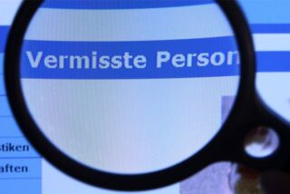 Hinter einer Lupe ist der Schriftzug «Vermisste Person» auf einem Fahndungsaufruf zu sehen.