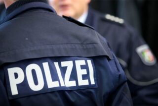 Zwei Polizisten in Uniform stehen beieinander