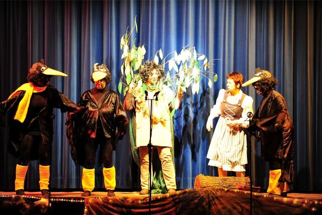 Eine Gruppe als Raben verkleidete Schauspieler steht auf der Bühne der Stadthalle Waltrop.