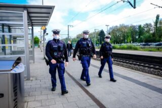 Zwei Mitarbeiter und eine Mitarbeiterin der Bundespolizei laufen über einen Bahnsteig vom Hauptbahnhof Recklinghausen.
