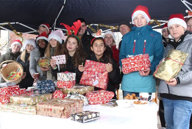 Das KiJuPa-Team an einem Stand auf dem Gelände vor dem „Laden“ im Waltroper Osten hinter einem Berg von Weihnachtsgeschenken.