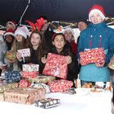 Das KiJuPa-Team an einem Stand auf dem Gelände vor dem „Laden“ im Waltroper Osten hinter einem Berg von Weihnachtsgeschenken.