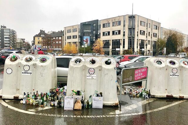 Überfüllte Glascontainer vor dem Kino