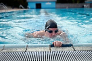 Ein Schwimmer am Rand eines Schwimmbeckens