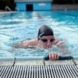 Ein Schwimmer am Rand eines Schwimmbeckens