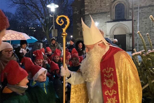 Ein als Nikolaus verkleideter Mann spricht in Recklinghausen mit als Wichtel verkleideten Kindern.