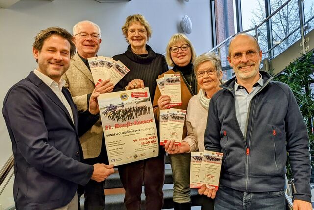 Die Veranstalter des Konzertes halten Plakate und Flyer in die Kamera.