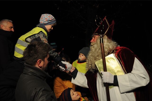 Der Nikolaus schüttelt einem Jungen die Hand.