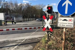 Schranken haben den Bahnübergang an der Dortmunder Straße in Castrop-Rauxel geschlossen. Eine Ampel leuchtet rot.