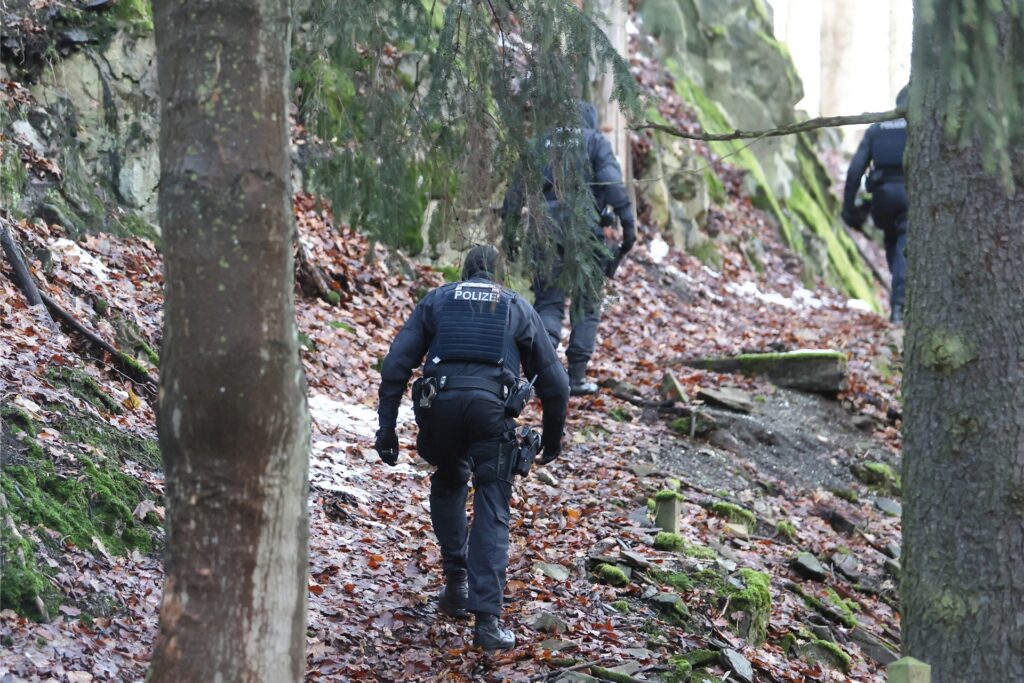 Einsatzkräfte der Polizei gehen einen Weg zum Jagdschloss Waidmannsheil, während der Durchsuchung durch die Polizei. Einsatzkräfte der Polizei gehen einen Weg zum Jagdschloss Waidmannsheil, während der Durchsuchung durch die Polizei.