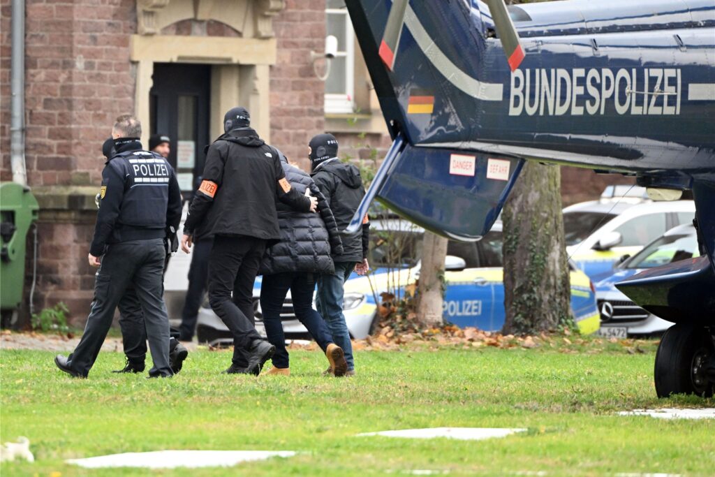 Eine Person wird von Polizisten aus einem Hubschrauber gebracht. Eine Person wird von Polizisten aus einem Hubschrauber gebracht.