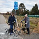 Prof. Dr. Uli Paetzel (Vorstandsvorsitzender der Emschergenossenschaft) und Bürgermeister Matthias Müller stehen auf dem Radweg am Backumer Bach in Herten.