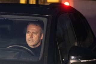 Hansi Flick sitzt am Steuer seines Autos.