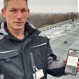 Ein Mann mit Handy und eine Sirene auf dem Dach