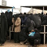 Frauen stellen sich für Hilfsgüter in einem syrischen Lager an.