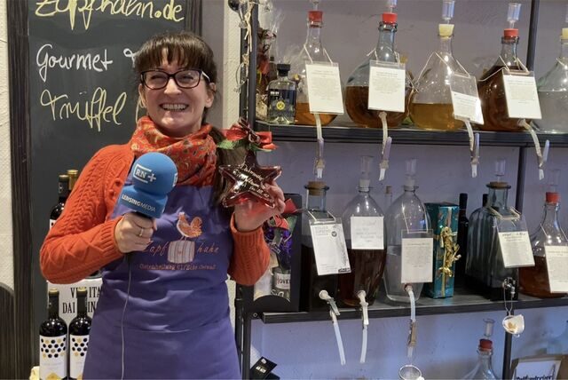 Simone Erpelding, Geschäftsinhaberin vom Geschäft Zapfhahn in der Dortmunder City, hält eine sternförmige Flasche eines Dortmunder Winterlikörs in der Hand.