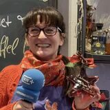 Simone Erpelding, Geschäftsinhaberin vom Geschäft Zapfhahn in der Dortmunder City, hält eine sternförmige Flasche eines Dortmunder Winterlikörs in der Hand.