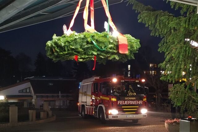 Im Eingang des Waltroper Krankenhauses hängt ein Adventskranz, im Hintergrund fährt ein Feuerwehr-Fahrzeug heran.