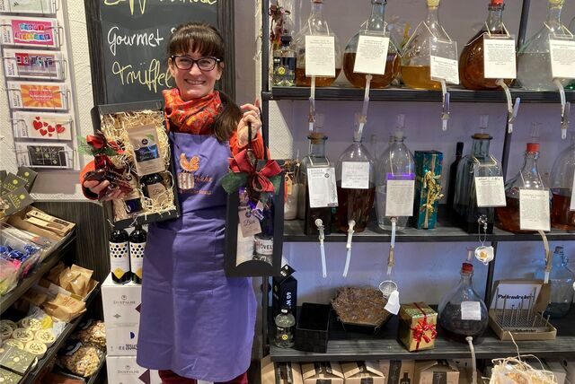 Simone Erpelding, Inhaberin des Geschäfts Zapfhahn in der Dortmunder City, hält verschiedene Weihnachtsgeschenke in den Händen.