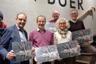 Mitglieder des Lionsclubs Haltern halten den aktuellen Adventskalender in den Händen.