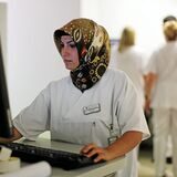 Eine medizinische Fachkraft trägt ein Kopftuch im Krankenhaus.