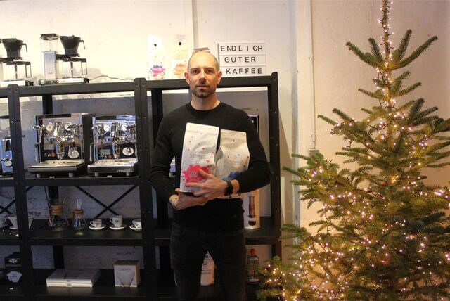 Daniel Strehlau steht im Kaffeeloft-Verkaufsraum neben einem Bio-Tannenbaum.
