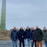Mitglieder der Bürgerwind Torfvenn vor einem 22 Jahre alten Windrad