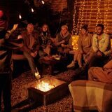 gruppe von menschen beim scharade spielen am lagerfeuer