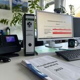 Aktenorder zwischen Telefon und Bildschirm