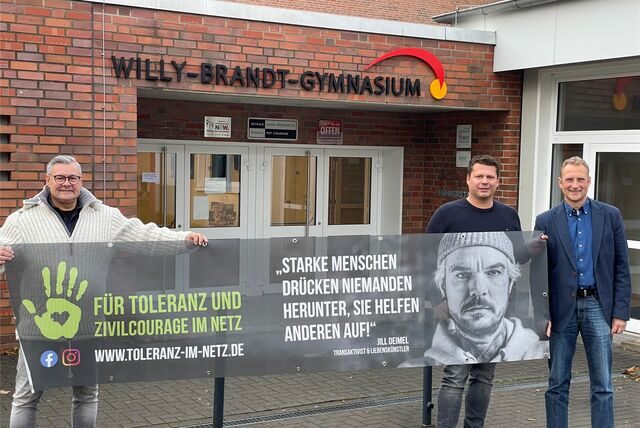 Die beiden Oer-Erkenschwicker Initiatoren Karsten Andreas und Christian Lenner übergeben Schulleiter Michael Rieder das Banner für die Kampagne.