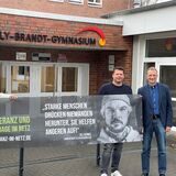 Die beiden Oer-Erkenschwicker Initiatoren Karsten Andreas und Christian Lenner übergeben Schulleiter Michael Rieder das Banner für die Kampagne.