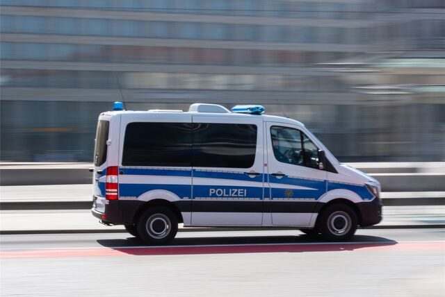 Ein Polizeiauto rast über eine Straße.