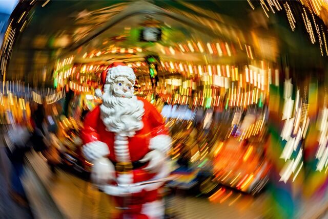 Eine lebensgroße Figur eines Weihnachtsmannes, aufgenommen mit kreisförmig bewegter Kamera und längerer Belichtungszeit (Symbolbild).