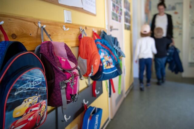 Kinderrucksäcke hängen im Eingangsbereich eines Kindergartens.