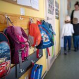 Kinderrucksäcke hängen im Eingangsbereich eines Kindergartens.