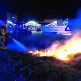 Ein Feuerwehrmann löscht nahe dem Autohaus Winkelheide in Waltrop einen kleinen Flächenbrand.