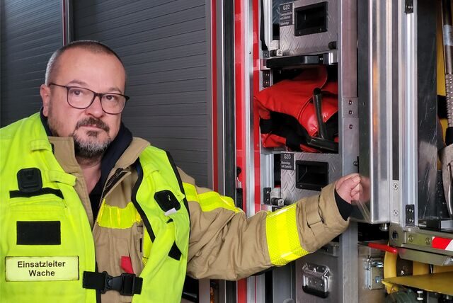 Brandamtmann Thomas Vosdellen an einem Feuerwehr-Einsatzfahrzeug
