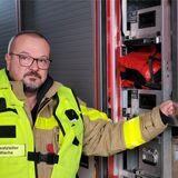 Brandamtmann Thomas Vosdellen an einem Feuerwehr-Einsatzfahrzeug