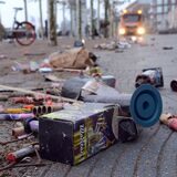Abgebrannte Feuerwerkskörper liegen auf der Straße, während sich die Feuerwehr nähert.