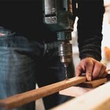 mann bohrt in holz